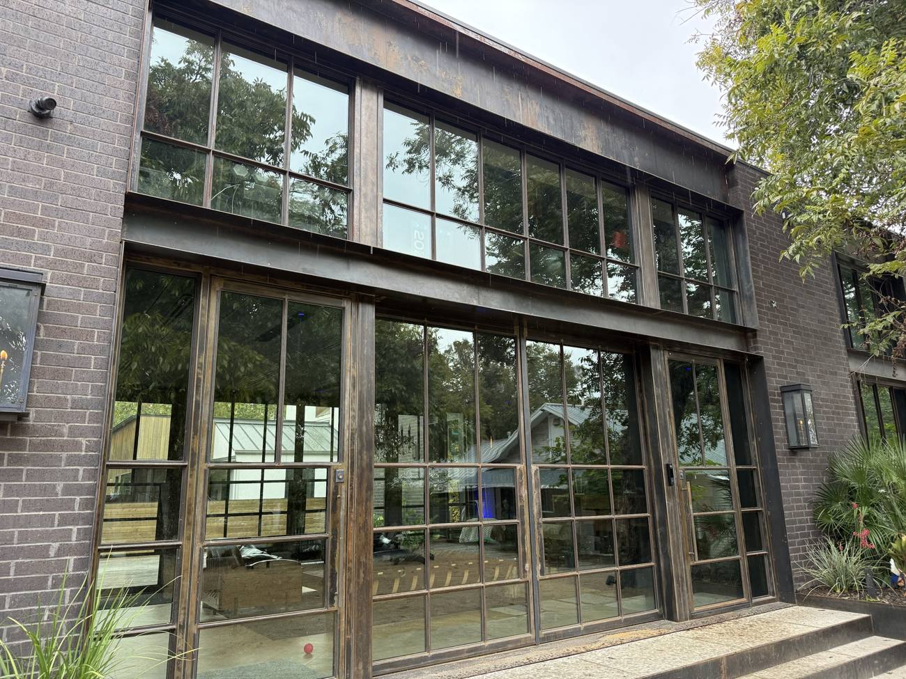 Two story steel window and door facade set in brick