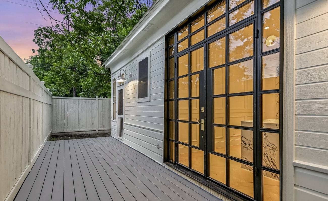 Black steel French doors with sidelites and transom on a white house